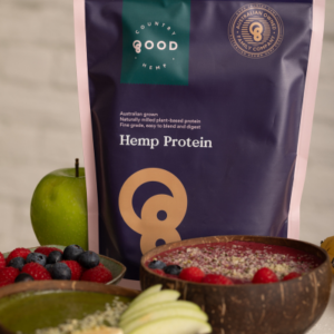 Packet of Australian hemp protein powder beside a fresh apple and a green smoothie bowl made with spinach, hemp, and yoghurt, topped with sliced banana and sprinkled with hemp seeds